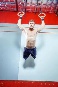 Muscle-up exercise young man doing intense cross fit workout at the gym on Stock Photos