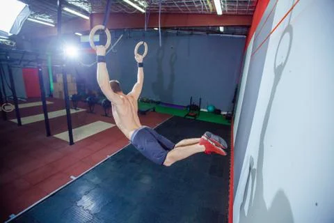 Muscle-up exercise young man doing intense cross fit workout at the gym on Stock Photos