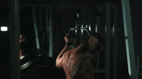 Muscle man execute back muscle exercises on pulldown bar machine at gym Stock Footage 68414680