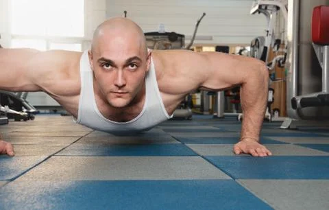 Muscle man making push ups in the gym Stock Photos