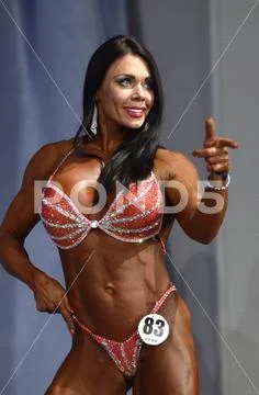Muscly girl in bikini posing on podium Stock Photos