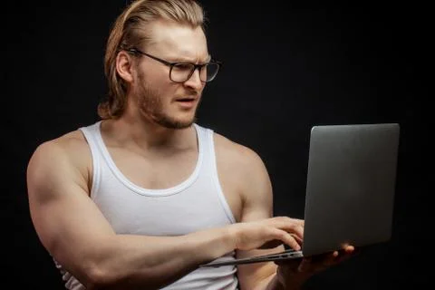 Muscular athlet learning to work with computer Foto stock