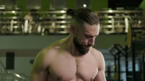 A muscular athlete does a bicep exercise with dumbbells. Sports Stock Footage 234629773
