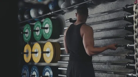 Muscular athlete loading squat bar in cinematic lighting Stock Footage 76726028
