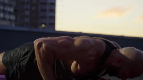 A muscular athlete trains by doing a push-up exercise. Video stock 256646324