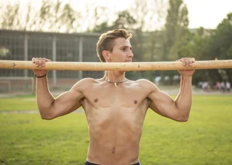 Muscular athlete trainting pull up, upper body shot. Stock-Fotos