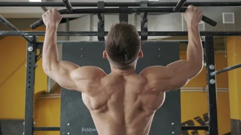 Muscular athletic man workout back muscles in the gym doing pull ups Video stock 169597206