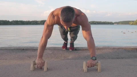 Muscular athletic young man doing pus? ups on the parallettes bar. Sport and  Stock-Footage 159468805