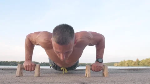 Muscular athletic young man doing pus? ups on the parallettes bar. Sport and  Stock-Footage 159469055