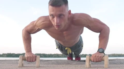 Muscular athletic young man doing pus? ups on the parallettes bar. Sport and  Stock-Footage 159469073
