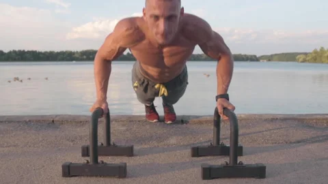 Muscular athletic young man doing pus? ups on the parallettes bar. Sport and  Stock-Footage 159469288