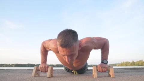 Muscular athletic young man doing pus? ups on the parallettes bar. Sport and  Video stock 159476794