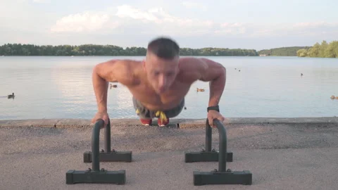 Muscular athletic young man doing pus? ups on the parallettes bar. Sport and  Stock-Footage 159477380