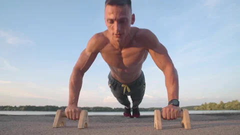 Muscular athletic young man doing pus? ups on the parallettes bar. Sport and  Stock-Footage 159477411