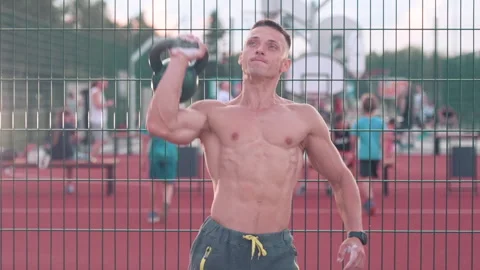 Muscular athletic young man exercise kettlebell lifts above head at the sport Stock-Footage 159478246