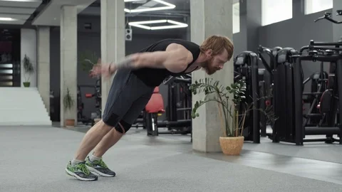 Muscular bearded man does push-ups in gym. Man doing Push Up Exercise in Gym Video stock 106468569
