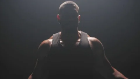 Muscular black man Jumping rope on a dark background, in slow motion Stock Footage