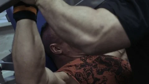 Muscular bodybuilder guy doing exercises in gym.Man working with weights in gym Stock Footage 70076475