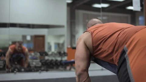 Muscular bodybuilder guy doing exercises in gym.Man working with weights in gym Stock Footage 70076612