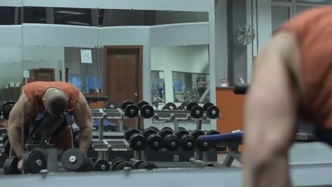 Muscular bodybuilder guy doing exercises in gym.Man working with weights in gym Stock Footage 70076622