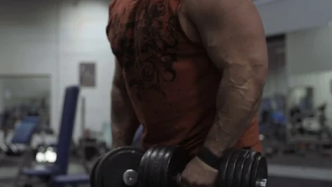 Muscular bodybuilder guy doing exercises in gym.Man working with weights in gym Stock Footage 70076689