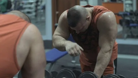 Muscular bodybuilder guy doing exercises in gym.Man working with weights in gym Stock Footage 70076857