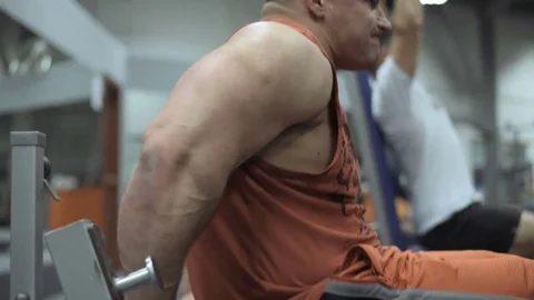 Muscular bodybuilder guy doing exercises in gym.Man working with weights in gym Stock Footage 70076952