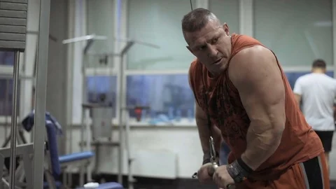 Muscular bodybuilder guy doing exercises in gym.Man working with weights in gym Stock Footage 70077059