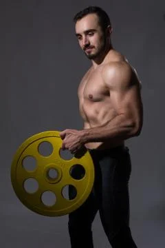 Muscular bodybuilder guy doing exercises with dumbbell Stock-Fotos
