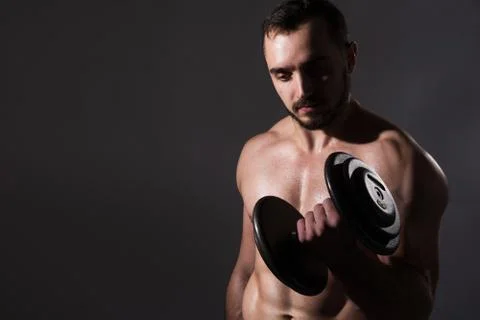 Muscular bodybuilder guy doing exercises with dumbbell Foto stock