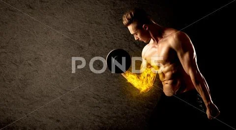 Muscular bodybuilder lifting weight with flaming biceps concept Stock Photos
