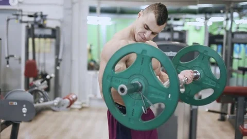 Muscular bodybuilder makes exercise for biceps in the gym Stock Footage 70511269