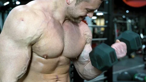 Muscular bodybuilder man doing arms exercises in gym. Stock Footage 107426464