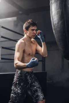 Muscular fighter prepare for practicing some kicks with punching bag Foto stock