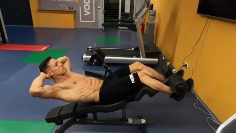 Muscular guy doing abs on the bench Video stock 138854732