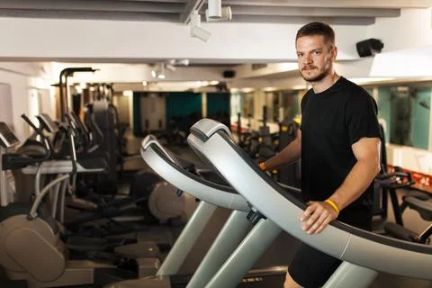 Muscular guy walking on a treadmill Stockfoto's