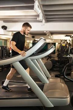 Muscular guy walking on a treadmill Stockfoto's