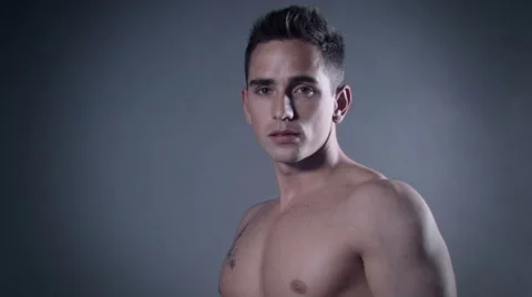 Muscular handsome man posing in dark studio. Vidéo 58145533