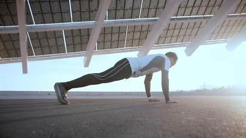 Muscular Hispanic man do exercise scene of push-ups against asphalt outdoor at Stock Footage 105754044