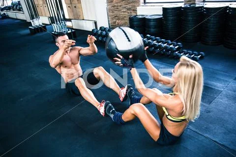 Muscular man and woman workout with fitball Stock Photos