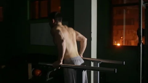 Muscular man bench performs on the uneven bars at the gym. Stock Footage 71418083