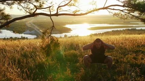 Muscular man boxer warming up his body on the field at sunset Stock Footage 219952324