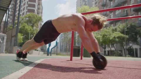 Muscular Man Doing Ab Wheel Rollouts at Outdoor Gym on the Street Stock Footage 260046089