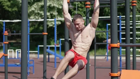 Muscular man doing abs exercise on outdoor sportsground Stock Footage 245267627