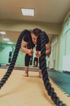 A muscular man doing arm exercise at gym. High quality photo Stock Photos