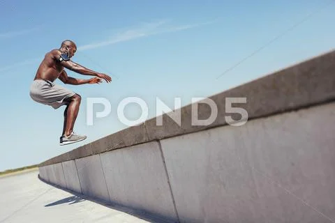 Muscular man doing box jumps outdoors. Stock Photos