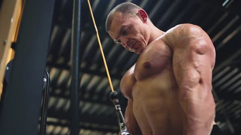 Muscular man doing cable rope triceps pull down exercise Stock Footage 111635083