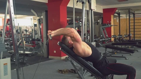 Muscular man doing cable rope triceps pull up exercise while working out in gym Stock Footage 114512769