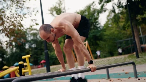 Muscular Man Doing Dips on Parallel Bars in a Park Stock-Footage 309040715