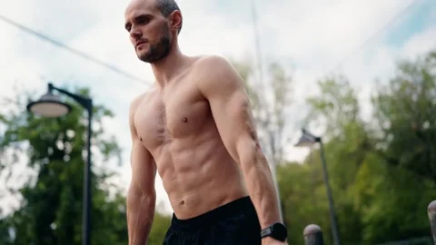 Muscular Man Doing Dips on Parallel Bars in a Park Video stock 310680717